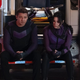 Clint and Kate sitting on on the rear bumper of an ambulance in their purple costumes in a scene from Hawkeye.